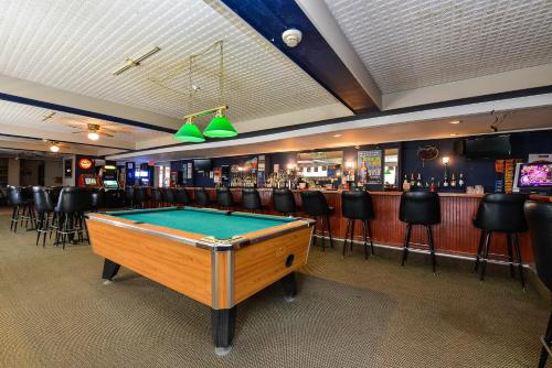 a pool table in a room with a bar at Travelodge by Wyndham Cleveland Airport in Brook Park