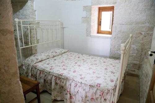 a white bedroom with a bed in a room at Trullo Montetrecarlini in Alberobello