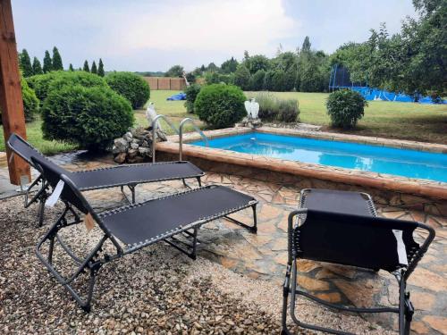 a couple of chairs sitting next to a swimming pool at Apartmani Neven in Irig