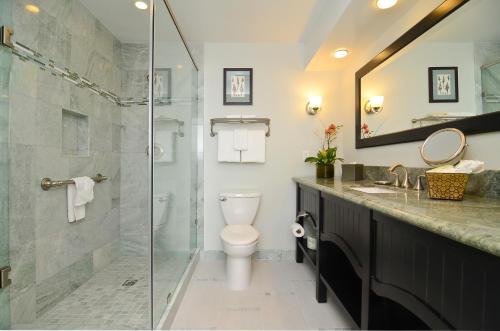 a bathroom with a toilet and a glass shower at Best Western Premier Hotel Del Mar in San Diego