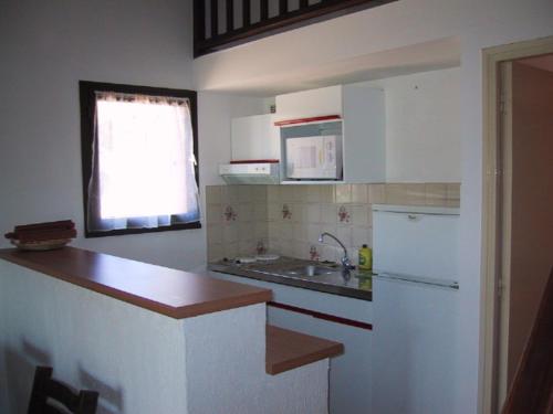 a kitchen with a sink and a refrigerator at Locations A Suara in Porto-Vecchio