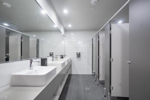 a bathroom with three sinks and a row of mirrors at Alberts Est 2017 in Innisfail