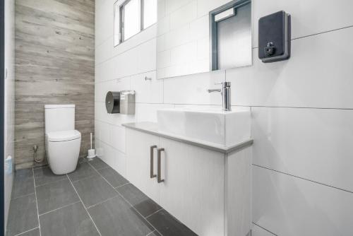 a white bathroom with a sink and a toilet at Alberts Est 2017 in Innisfail