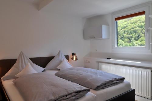 un letto con cuscini sopra in una stanza con finestra di Hotel Zur Post a Klotten