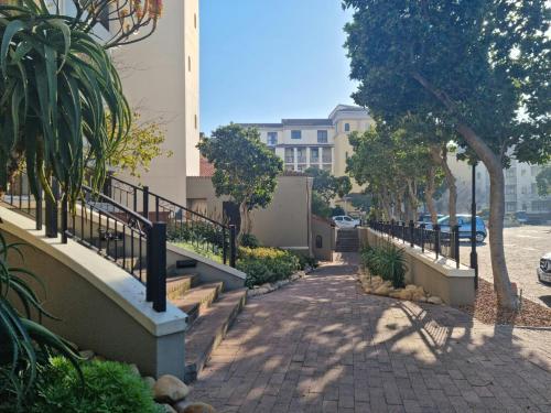 a sidewalk with stairs and trees and a building at Island Club by Smart City Stays in Cape Town