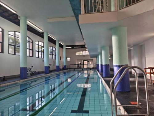 an indoor swimming pool with blue columns and a swimming pool at Island Club by Smart City Stays in Cape Town