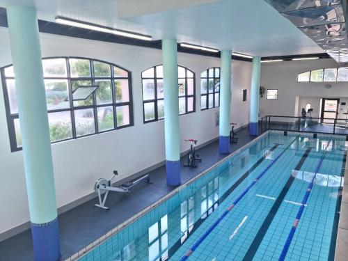a swimming pool with blue columns in a building at Island Club by Smart City Stays in Cape Town