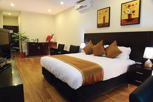 a hotel room with a bed and a television at Timor Plaza Hotel & Apartments in Dili