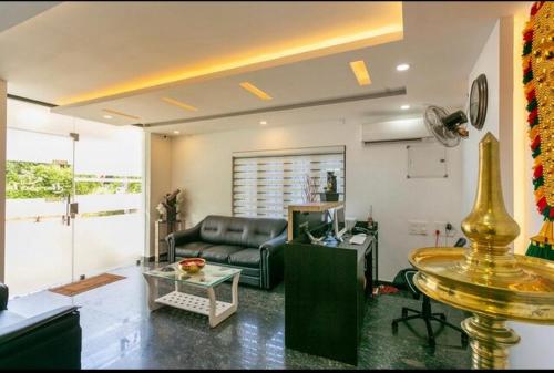 a living room with a couch and a table at Thenmala Hormuz Inn in Kolattupuzha