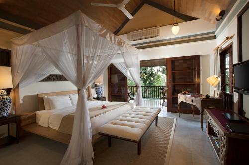 a bedroom with a large bed with a canopy at Plataran Borobudur in Borobudur