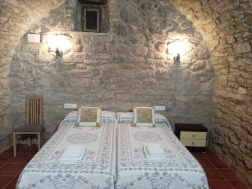 een slaapkamer met een bed in een stenen muur bij Casa "La Huerta" DE RODA DE ISABENA in Roda de Isábena