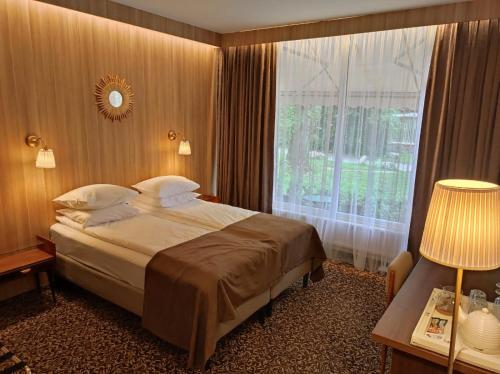 une chambre d'hôtel avec un lit et une fenêtre dans l'établissement Nėris Inn Terraces, à Vilnius
