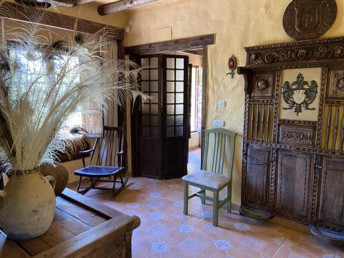 una habitación con una mesa y un jarrón con una planta en Cortijo rural Archidona, en Archidona