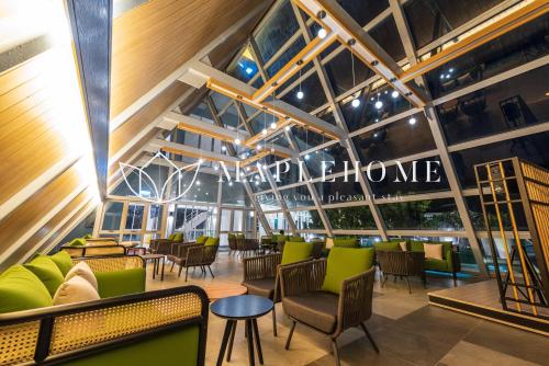 a view of a restaurant with green chairs and tables at Windmill Premier Suites Genting Highlands in Genting Highlands