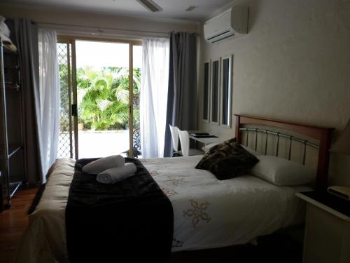 a bedroom with a bed and a large window at Oceana Holiday Units in Coffs Harbour