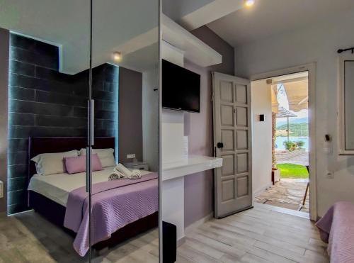 two pictures of a bedroom with a bed and a tv at Flisvos Seaside Apartments in Lygia