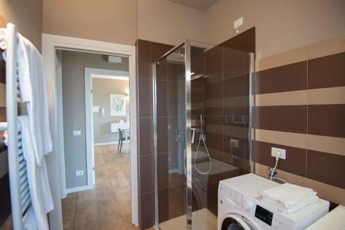 een badkamer met een douche en een wasmachine bij Sirmio Apartments - Narnia Stay in Sirmione