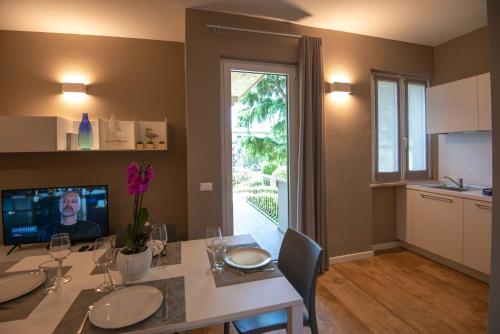 a dining room with a table and a kitchen at Sirmio Apartments - Narnia Stay in Sirmione