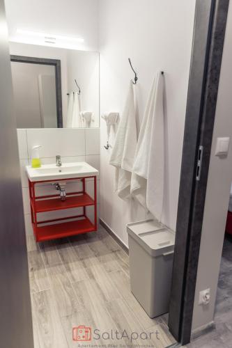 a bathroom with a red vanity and a white sink at SaltApart Apartament Plac Solny Wrocław in Wrocław