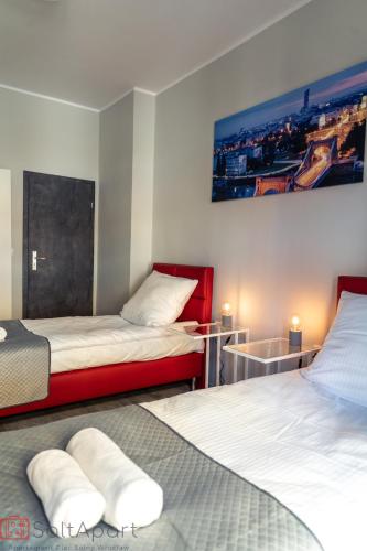 a bedroom with two beds and a painting on the wall at SaltApart Apartament Plac Solny Wrocław in Wrocław