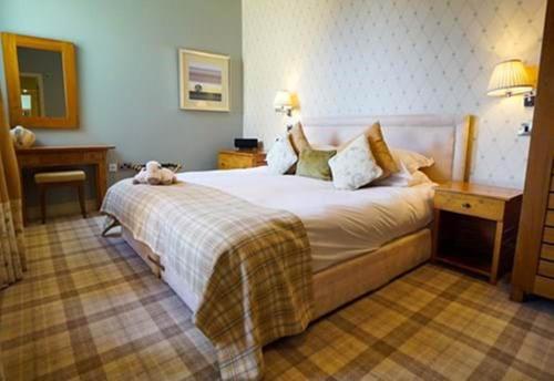 a bedroom with a bed with a dog laying on it at Feversham Arms Hotel & Verbena Spa in Helmsley