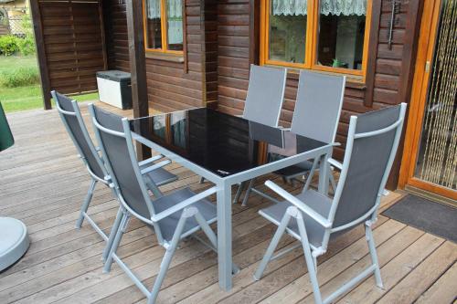 una mesa y cuatro sillas en una terraza en Holzblockhaus mit Kamin am Kite , Surf und Badestrand, en Loissin