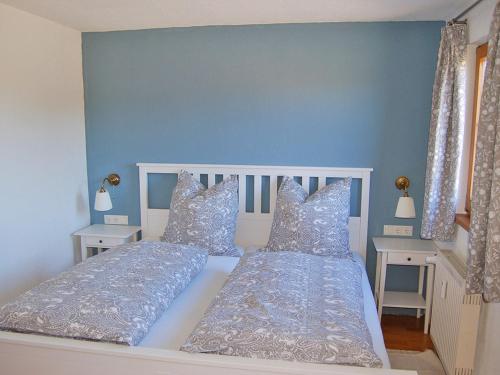 a bedroom with two beds with blue walls and pillows at Ferienwohnung am Wirtsgarten in Bad Birnbach