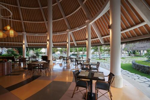 a restaurant with tables and chairs and a large ceiling at Sudamala Resort, Komodo, Labuan Bajo in Labuan Bajo