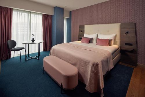 a hotel room with a large bed and a table at Van der Valk Hotel Haarlem in Haarlem