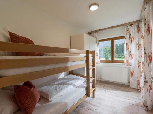 two bunk beds in a room with a window at Ferienhaus am Erlachhof in Söll