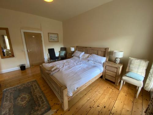 a bedroom with a large bed and a chair at The Old Flax Mill Yoga Retreat in Coleraine
