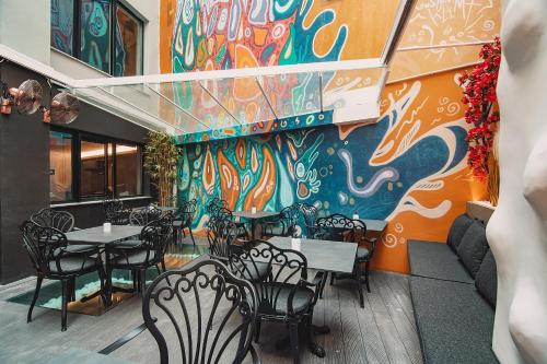 a restaurant with tables and chairs and a colorful wall at Project 3 Urban Chic Hotel in Athens