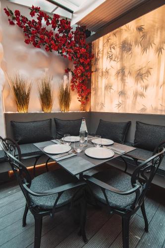 a dining room with a table with chairs and red flowers at Project 3 Urban Chic Hotel in Athens