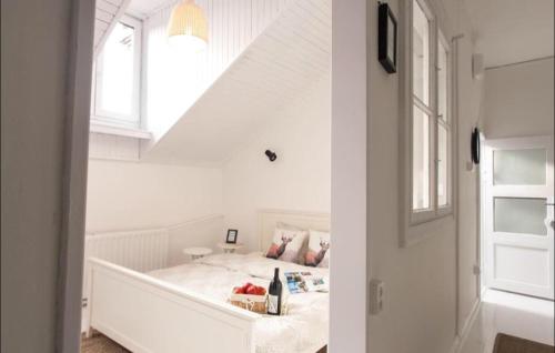 a white bedroom with a bed with a window at Sopot Retro Apartment in Sopot