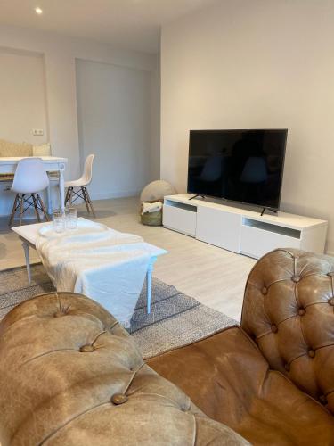 - un salon avec une télévision à écran plat et deux chaises dans l'établissement Apartamento M Garaje Playa Golf, à Zarautz