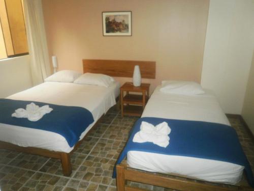 two beds in a hotel room with towels on them at Hospedaje La Videna in Lima