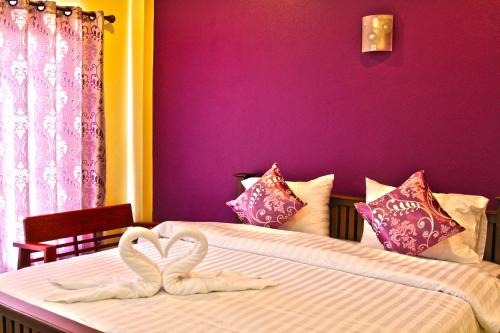 two white swans towels on a bed in a bedroom at Blue House Sukhothai in Sukhothai