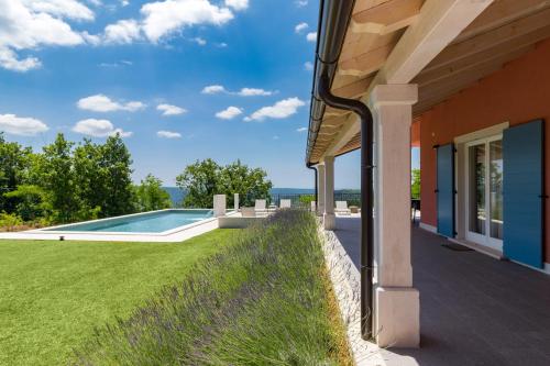 uma casa com piscina ao lado de um quintal em Rainis Hill Top Villa em Oprtalj