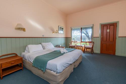 a bedroom with a large bed and a table at Acheron Valley Country Retreat in Acheron