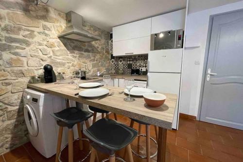- une cuisine avec un comptoir et quelques tabourets dans l'établissement LE JAD Joli F2 proche Gare, Arènes avec terrasse privée, à Nîmes