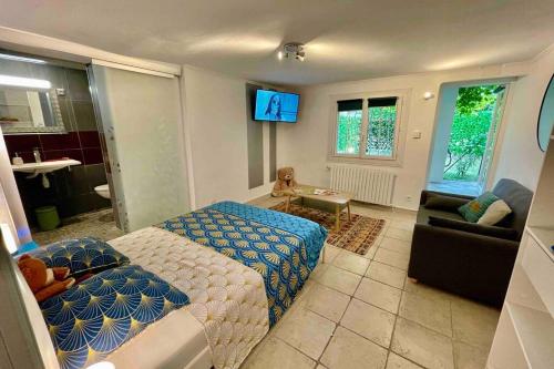 - un salon avec un lit, un canapé et une télévision dans l'établissement LE JAD Joli F2 proche Gare, Arènes avec terrasse privée, à Nîmes