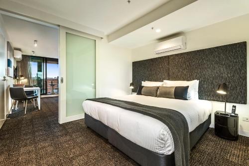 una camera con un grande letto e una porta scorrevole in vetro di Corporate Living Accommodation Abbotsford a Melbourne