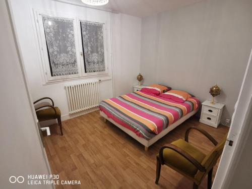 - une chambre avec un lit et deux chaises dans l'établissement T2 cosy proche des pistes, à Briançon