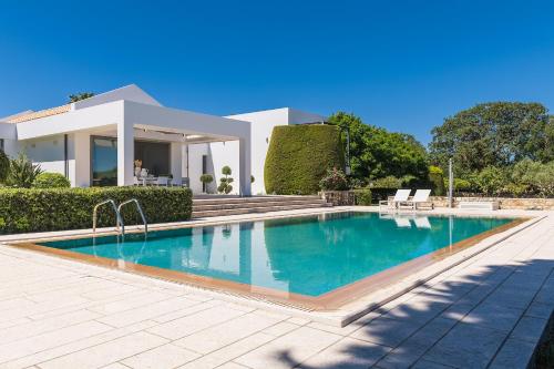 a swimming pool in front of a house at Villa Syndriani in Paradeísi