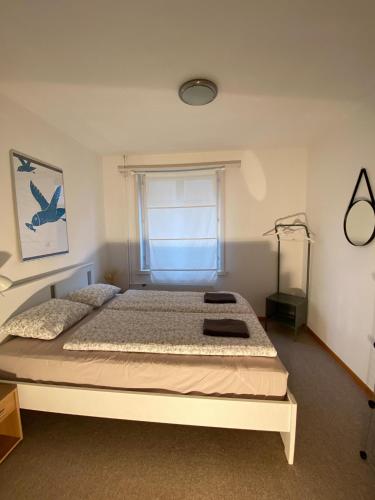 a bedroom with a large bed with a window at NEB-THUN LODGE`s Appartement 1 Hilterfingen Ringstrasse 6 in Thun