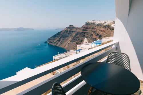a table and chairs on a balcony overlooking the ocean at Kafieris View in Firostefani