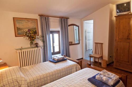 a hotel room with two beds and a window at Villa Pilar in Toscana con piscina ultrapanoramica in Montevettolini