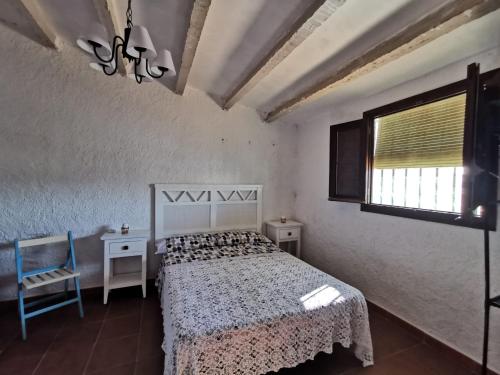- une chambre avec un lit, une chaise et une fenêtre dans l'établissement Casa de la Parra, à Bédar
