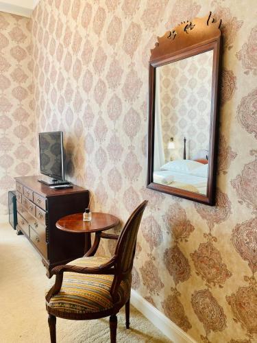 a room with a table and a mirror and a chair at OPERA16 Guestrooms in Budapest