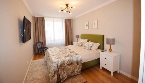 a bedroom with a bed and a white night stand at Luxury Apartment Central in Târgu-Mureş